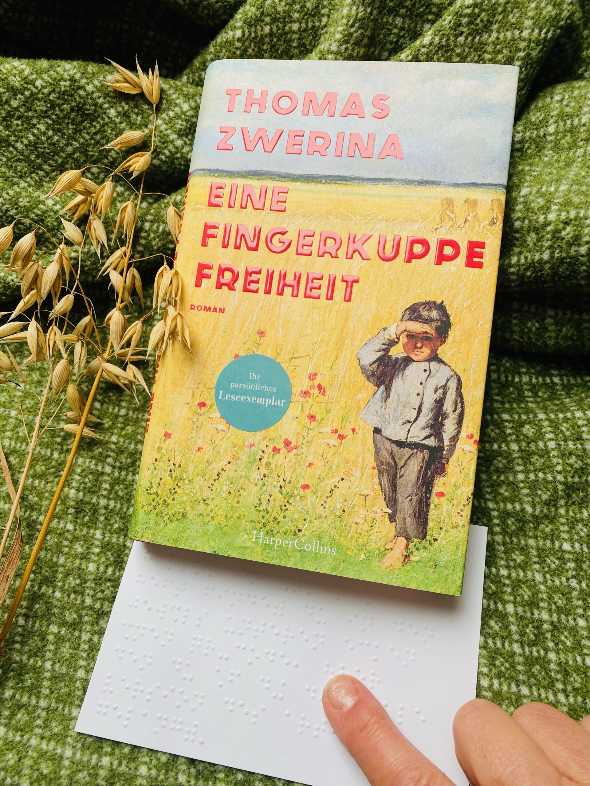 Ein Buchcover mit einem kleinen Jungen in einem Feld. Text: Thomas Zwerina, eine Fingerkuppe Freiheit